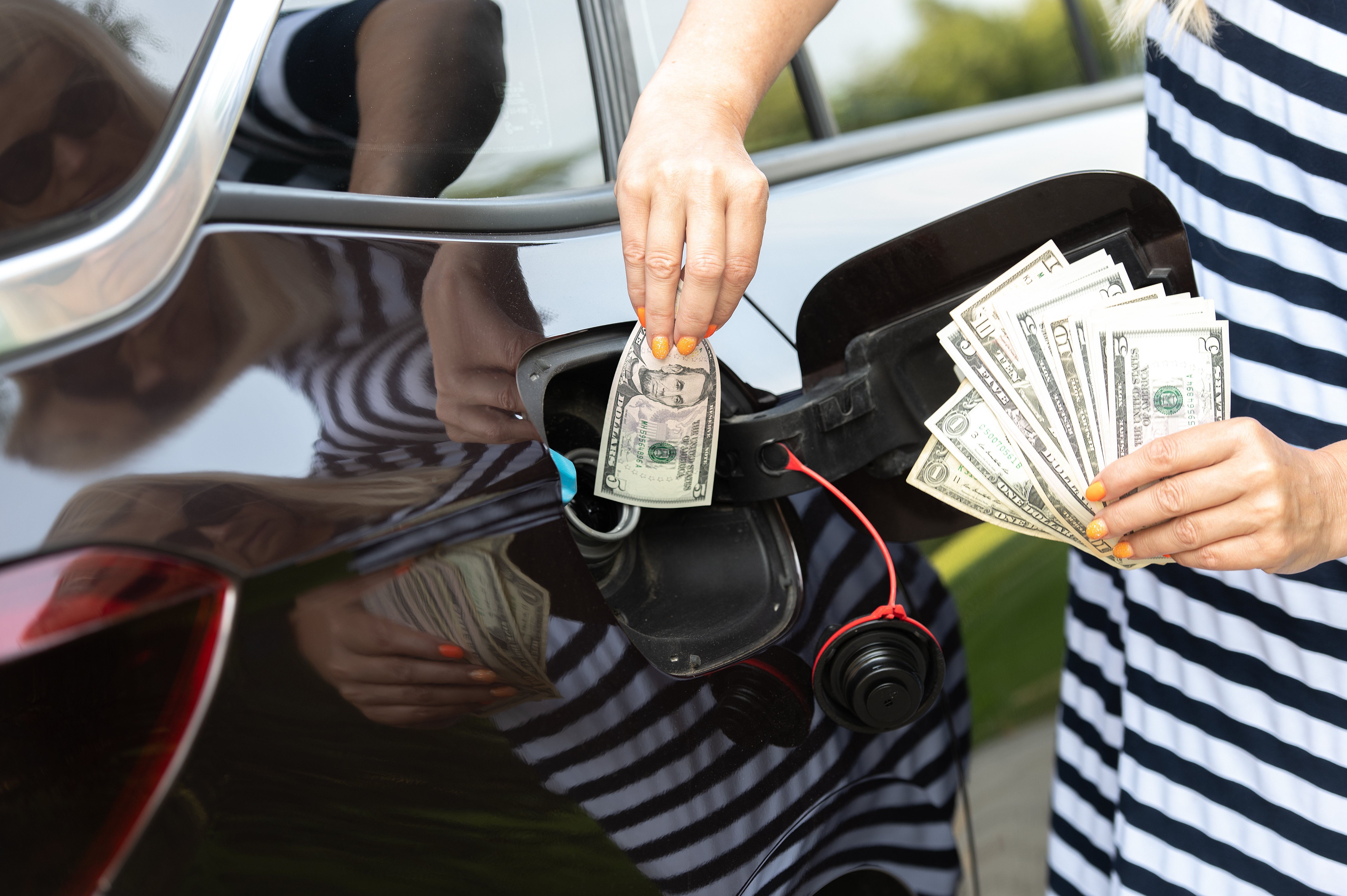 vecteezy_transport-costs-hand-inserting-money-in-car-fuel-tank_47976754